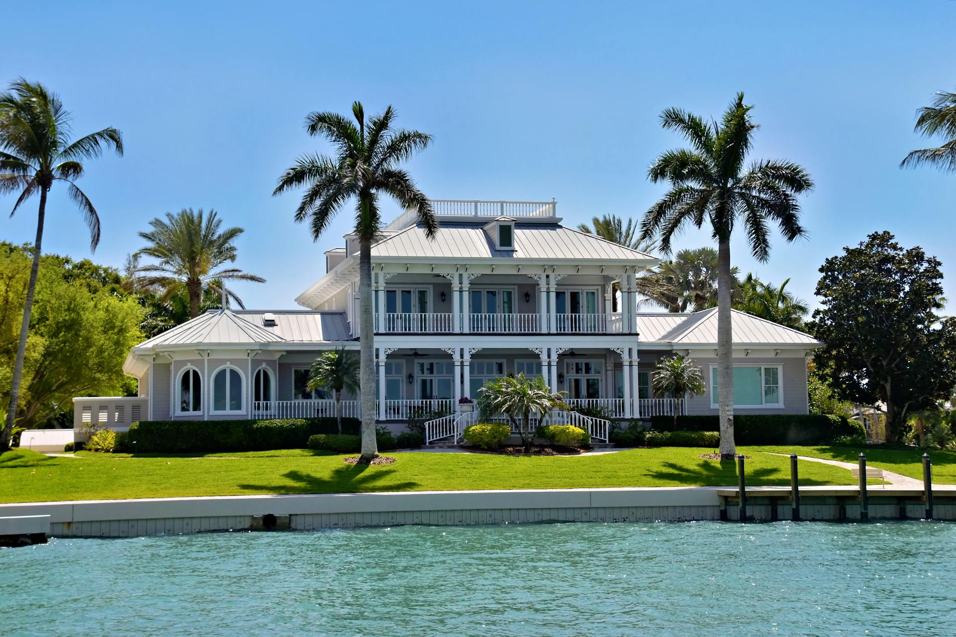 Elegant waterfront villa with palm trees and colonial architecture
